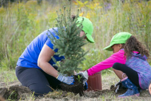 Young woman and child planting a tree.