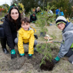 http://Two%20young%20boys%20and%20mom%20planting%20tree.