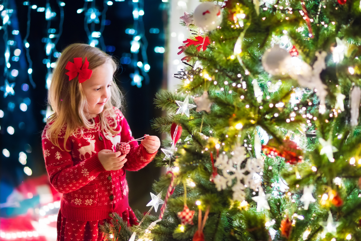 young girl decorating tree, image from Canva